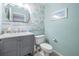 Bright powder room with marble countertop, stainless faucet, and floral accent wall at 3029 Brookfield Ln, Clearwater, FL 33761
