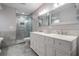 Well-lit main bathroom with double vanity and walk-in shower with glass door at 3029 Brookfield Ln, Clearwater, FL 33761