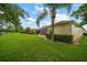 View of a lush green lawn, manicured bushes and a screened-in patio in the backyard at 3137 Banyan Hill Ln, Land O Lakes, FL 34639