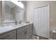 Modern bathroom with dual sinks, gray cabinets, marble countertop, and a large mirror at 3137 Banyan Hill Ln, Land O Lakes, FL 34639