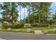 Community sign entrance surrounded by mature trees and landscaping at 3137 Banyan Hill Ln, Land O Lakes, FL 34639