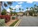 Community gate entrance with lush landscaping featuring palm trees at 3137 Banyan Hill Ln, Land O Lakes, FL 34639