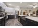Open-concept kitchen with white cabinets, stainless appliances, and gray backsplash at 3137 Banyan Hill Ln, Land O Lakes, FL 34639