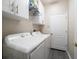 Bright laundry room boasts a washer, dryer, cabinet storage and neutral paint at 3137 Banyan Hill Ln, Land O Lakes, FL 34639