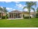 A screened patio area with furniture, a grill and a palm tree in the backyard at 3137 Banyan Hill Ln, Land O Lakes, FL 34639