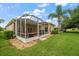 A screened patio area with furniture, a grill and a view of the beautiful backyard at 3137 Banyan Hill Ln, Land O Lakes, FL 34639