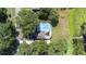 Aerial view of screened-in pool and backyard with a dock on the lake at 35836 Lakeshore Dr, Dade City, FL 33525
