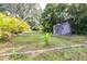 Large grassy backyard with storage shed and palm trees at 35836 Lakeshore Dr, Dade City, FL 33525