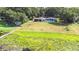 Aerial shot of a backyard featuring a large lot, wooden dock, pond, and screened-in pool of the home at 35836 Lakeshore Dr, Dade City, FL 33525