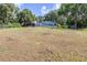 Large backyard featuring a screened-in pool and mature trees at 35836 Lakeshore Dr, Dade City, FL 33525
