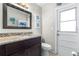 Cozy bathroom with dark wood cabinets, granite countertop, decorative mirror, and charming nautical decor at 35836 Lakeshore Dr, Dade City, FL 33525