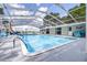 Covered swimming pool surrounded by beautiful landscaping at 35836 Lakeshore Dr, Dade City, FL 33525