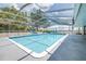 Large in-ground pool with screened enclosure, slide, and patio furniture, perfect for enjoying outdoor living at 35836 Lakeshore Dr, Dade City, FL 33525