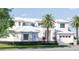 Magnificent home showcasing a light brick facade, dark framed windows, palms, and a manicured front yard at 38 Ladoga Ave, Tampa, FL 33606