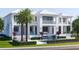 Elegant waterfront home with a pool, waterfall feature, glass balcony railings, and palm trees at 38 Ladoga Ave, Tampa, FL 33606