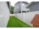 Backyard features artificial turf, modern fence, and a wooden playhouse at 403 S Fremont Ave # 3, Tampa, FL 33606