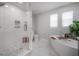 Bright bathroom featuring glass enclosed shower, soaking tub, and white marble accents at 403 S Fremont Ave # 3, Tampa, FL 33606