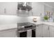Modern kitchen with stainless steel oven, range hood, white backsplash and countertops at 403 S Fremont Ave # 3, Tampa, FL 33606