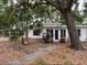 Single story home with tropical landscaping and mature shade tree in the front yard at 4050 Iris N St, St Petersburg, FL 33703