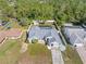 Aerial view of a charming property with a screened-in pool, fenced backyard, and mature trees at 4399 Dior Rd, Spring Hill, FL 34609