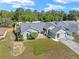 Aerial view of a landscaped property with a well-maintained lawn, driveway, and a fenced backyard at 4399 Dior Rd, Spring Hill, FL 34609