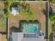 Aerial view of a backyard with a pool, mature trees, shed, and firepit at 4399 Dior Rd, Spring Hill, FL 34609