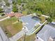 Aerial view of a home featuring a screened-in pool, fenced yard, and mature trees at 4399 Dior Rd, Spring Hill, FL 34609