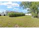 Green grassy backyard with white fencing and surrounding trees at 4399 Dior Rd, Spring Hill, FL 34609
