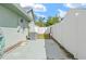 Side yard view with white fencing, AC unit, and door to the home at 4399 Dior Rd, Spring Hill, FL 34609
