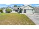 Inviting single-story home featuring a two-car garage, decorative front door, and lush green lawn at 4399 Dior Rd, Spring Hill, FL 34609