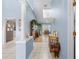 Hallway with architectural columns leading into a living room with wood floors, skylights, and modern decor at 4399 Dior Rd, Spring Hill, FL 34609