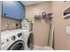 Functional laundry room with washer, dryer, storage shelves and blue cabinets to facilitate household tasks at 4399 Dior Rd, Spring Hill, FL 34609