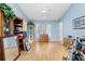 Bright living room featuring wood floors, blue walls, a ceiling fan, and natural light from large windows at 4399 Dior Rd, Spring Hill, FL 34609