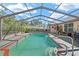 Screened in backyard swimming pool with steps and handrail at 4399 Dior Rd, Spring Hill, FL 34609