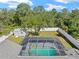 Aerial shot of the screened-in backyard pool and fenced yard backed by mature trees at 4399 Dior Rd, Spring Hill, FL 34609
