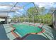 Large screened pool with brick trim surrounded by lush plants at 4399 Dior Rd, Spring Hill, FL 34609