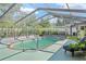 Backyard screened-in pool with clear water and a seating area at 4399 Dior Rd, Spring Hill, FL 34609
