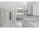 Hallway view of luxury bathroom, featuring soaking tub, dual vanity, and stylish marble tile flooring at 4515 W North A St # 6, Tampa, FL 33609