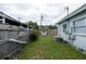 Backyard view featuring side of home, fencing, a lawn area, and outbuildings at 4705 Murray Hill Dr, Tampa, FL 33615