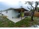 View of the home's backyard with a covered patio, green lawn, and wooden fence at 4705 Murray Hill Dr, Tampa, FL 33615