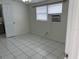 Bedroom features white tile floors, a window AC unit, and neutral walls at 4705 Murray Hill Dr, Tampa, FL 33615