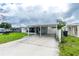 View of the single story home, including the carport and screened in patio at 4705 Murray Hill Dr, Tampa, FL 33615