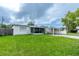 Home exterior featuring a lush green lawn, carport, and screened-in porch at 4705 Murray Hill Dr, Tampa, FL 33615
