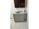 Laundry room with a gray vanity, overhead dark wood cabinets, and tile floors at 4705 Murray Hill Dr, Tampa, FL 33615