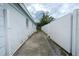 View of the side yard featuring a concrete walkway and a white fence for privacy at 4705 Murray Hill Dr, Tampa, FL 33615