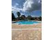 Large community pool surrounded by palm trees and lounge chairs at 500 Belcher S Rd # 109, Largo, FL 33771
