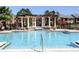 Community pool with trellis, columns and lush landscaping at 500 Belcher S Rd # 109, Largo, FL 33771