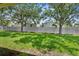 Grassy backyard featuring a white vinyl fence, mature trees, and ample space for outdoor activities at 5015 58Th E Ter, Bradenton, FL 34203