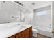 Bright bathroom with a white tiled shower, wood vanity, and large mirror, offering a clean and modern design at 5015 58Th E Ter, Bradenton, FL 34203