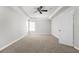 Neutral carpeted bedroom with windows, ceiling fan, and doorway, offering space to personalize at 5015 58Th E Ter, Bradenton, FL 34203